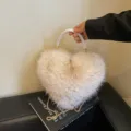 Detail of an ivory heart-shaped plush bag with a braided white handle and gold chain strap - Off White