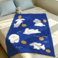 Blue plush blanket spread on a bed, decorated with white puppy illustrations and orange dots - Dark Blue Cartoon Dog (FMTA177202) / 60x40cm