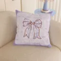 Close-up of a lavender plush cushion with a white polka-dot bow, placed on a beige sofa - 35x35cm / Cushion Cover Only / Purple Bow