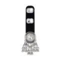 Close-up of a silver filigree ornament with a clear center stone and dangling bell charms - Clear
