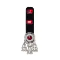 Close-up of a black velvet base with red gems and ornate silver bell tassels hanging below - Red