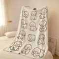 Plaid polaire blanc doux à motifs de chiens dessinés en brun et joues roses, posé sur un lit - Bichon Blanc avec Rougeur (FMTA034905) / 60x40cm