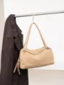 Tan suede bag hanging from a metal rail, with slim handles, silver hardware and a tassel charm - 35x12x23cm / Khaki