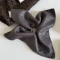 Detalle de un pañuelo gris para el cabello, efecto satén, con jacquard de leopardo y bordes cosidos - Pañuelo Cuadrado Gris