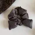 Detalle de un coletero gris oscuro con forma de lazo y jacquard de leopardo sutil, sobre fondo blanco - Coletero con Lazo Gris / Gris
