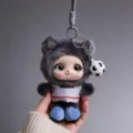 Close-up of a gray furry keychain character with red stripes, blue shoes and a soccer ball charm - Black and White Striped Style (540081) / Black