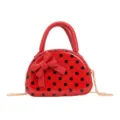 Front view of a glossy red mini bag with black polka dots, a bow and gold-tone chain on white - Red