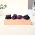 Lámpara nocturna con cuatro cristales naturales de amatista morada sobre una base de madera clara - Amatista