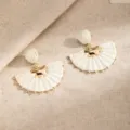 White woven half-moon earrings with gold-tone accents and tiny beads, displayed on linen - White (E6807)