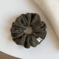 Gros plan sur un chouchou froncé en tissu à carreaux, aux tons vert foncé, brun et beige - Chouchou / Vert Abricot