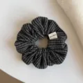 Gros plan sur un chouchou en tissu à carreaux gris foncé, aux plis souples et texture visible - Chouchou / Noir