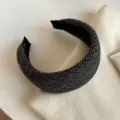 Gros plan sur un serre-tête large en tissu à carreaux gris foncé, doublé de noir, posé sur du tricot - Serre-tête Large / Noir et Gris