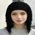 Black crocheted dreadlock wig hat with open-knit crown and short braided tassels, worn by model - Adult: 57-59cm / Medium-Length Hair / Black
