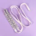 White satin bridal sash with silver rhinestone floral embellishments, laid flat on purple background. - Luxury Floral Daily Style (WS-J259S)
