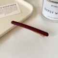 Barrette à cheveux bordeaux mate, au fini sobre, avec une pince métallique dorée bien visible - Bordeaux