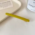 Barrette fine en métal jaune-vert mat, au design allongé avec une pince dorée visible - Jaune