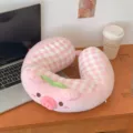 Pink plush U-shaped neck pillow with a cute pig face, gingham panels, and green leaf detail - Pig Shape / Pink