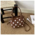 Borsa marrone a pois bianchi con manici in pelle, esposta su un tappeto intrecciato accanto a libri - senza ciondolo / Marrone