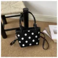 Dettaglio dei pois bianchi, dei manici annodati e della tracolla regolabile su una borsa nera - senza ciondolo / Nero
