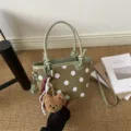 Borsa verde in finta pelle scamosciata a pois bianchi, con manici verde chiaro e charm orsetto - con portachiavi / Verde