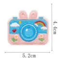 Close-up van een blauw-roze geborduurde cameravorm met konijnenoren, regenboog, wolken en bloemen - Konijnenoor Camera (9344-2)