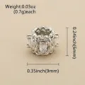 Gros plan sur une perle ajourée argentée, avec zircons transparents et motif floral sculpté - Argent