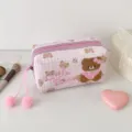 Detailansicht von rosa Karostoff, bestickten Teddybären, Reißverschluss und flauschigen Pompons - Rosa