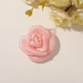 Close-up of a layered pink satin fabric rose laid flat beside cream-colored floral props - Style 4(A76-1-51-56) / 1 Piece/Pack