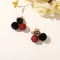 Close-up of black velvet and red woven ball earrings with crystal flower studs on a pale surface. - Style 9 (202610)