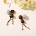 Flat lay of mismatched earrings with woven balls, brown pendants, bead chains and gold-tone pins - Style 15 (202610)