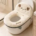 Sheep-shaped fluffy cover with embroidered face, lettering and visible zip edge on a toilet - Sheep / White