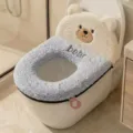 Close-up of a plush bear face above a gray fuzzy toilet seat cover, with “bear” embroidery and pink pull tab - Teddy Bear / Blue