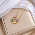 Goldfarbene Kleeblattkette mit vier bunten Herzsteinen auf beiger Schmuckschatulle - Gold Buntes Herz Kleeblatt (X1507) / Gold und Mehrfarbig