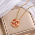 Goldfarbene Kleeblattkette mit vier roten herzförmigen Steinen auf einer beigen Schmuckbox - Gold Orange Herz Kleeblatt (X1511) / Gold und Orange