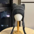 Close-up of the dark gray rib-knit texture, cat-ear crown and long braided ties on a winter hat - Adult 54-60 One Size / Black