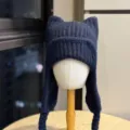 Navy rib-knit hat with cat ears, long ear flaps and braided ties, displayed on a mannequin - Adult 54-60 One Size / Navy Blue