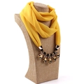 Dettaglio della sciarpa collana in chiffon giallo con pendenti in ambra e metallo dorato - Giallo