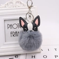 Close-up of a grey pom-pom puppy keychain with black and white leather French bulldog head - Silver 8-Shape Clasp / Medium Grey