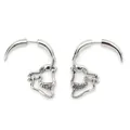 Detailed macro view of silver punk skull jawbone earrings with gothic spike design - Silver