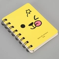 Close-up of yellow A7 spiral notebook with cartoon smiley and black double-wire binding - Expression-Yellow