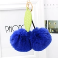 Detail of royal blue cherry pompom keychain with green faux leather leaf and gold clasp - Sapphire Blue
