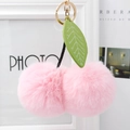 Detail of pink faux fur cherry pom-poms keychain with green leather leaf and gold hardware - Light Pink