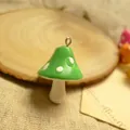 Macro view of green mushroom resin pendant with white dots and silver metal hook - Green