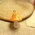 Detailed view of an orange resin mushroom charm with white spots and a metal ring for DIY - Orange