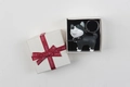 Close-up of a cartoon husky keychain in a cream gift box with a red silk ribbon - Grey Dog with Gift Box