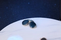 Detail of silver enamel sunglasses brooch with deep blue lenses on a marble base - Sunglasses - Silver/Blue