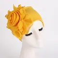 Gros plan d'un élégant turban jaune pour femme orné d'une grande fleur latérale décorative - Jaune