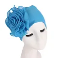 Detail of the bright blue floral turban featuring a large 3D layered rose decoration - Lake Blue