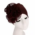 Detailed close-up of dark brown stretch turban with a large side flower on a display head - Coffee