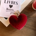 Detail of red plush heart keychain with gold clasp on rustic wood background - Burgundy